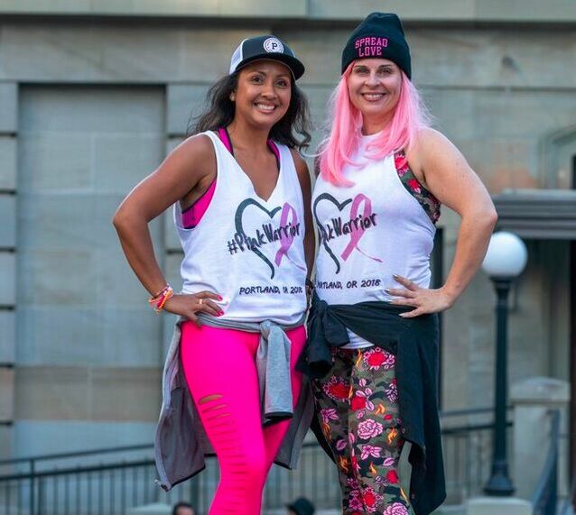 Satha Berres and Veronica Lebednik, co-founders of the Party in Pink at Pioneer Square, pose together onstage.